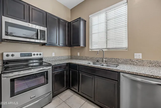 a kitchen with stainless steel appliances granite countertop white cabinets and a stove top oven