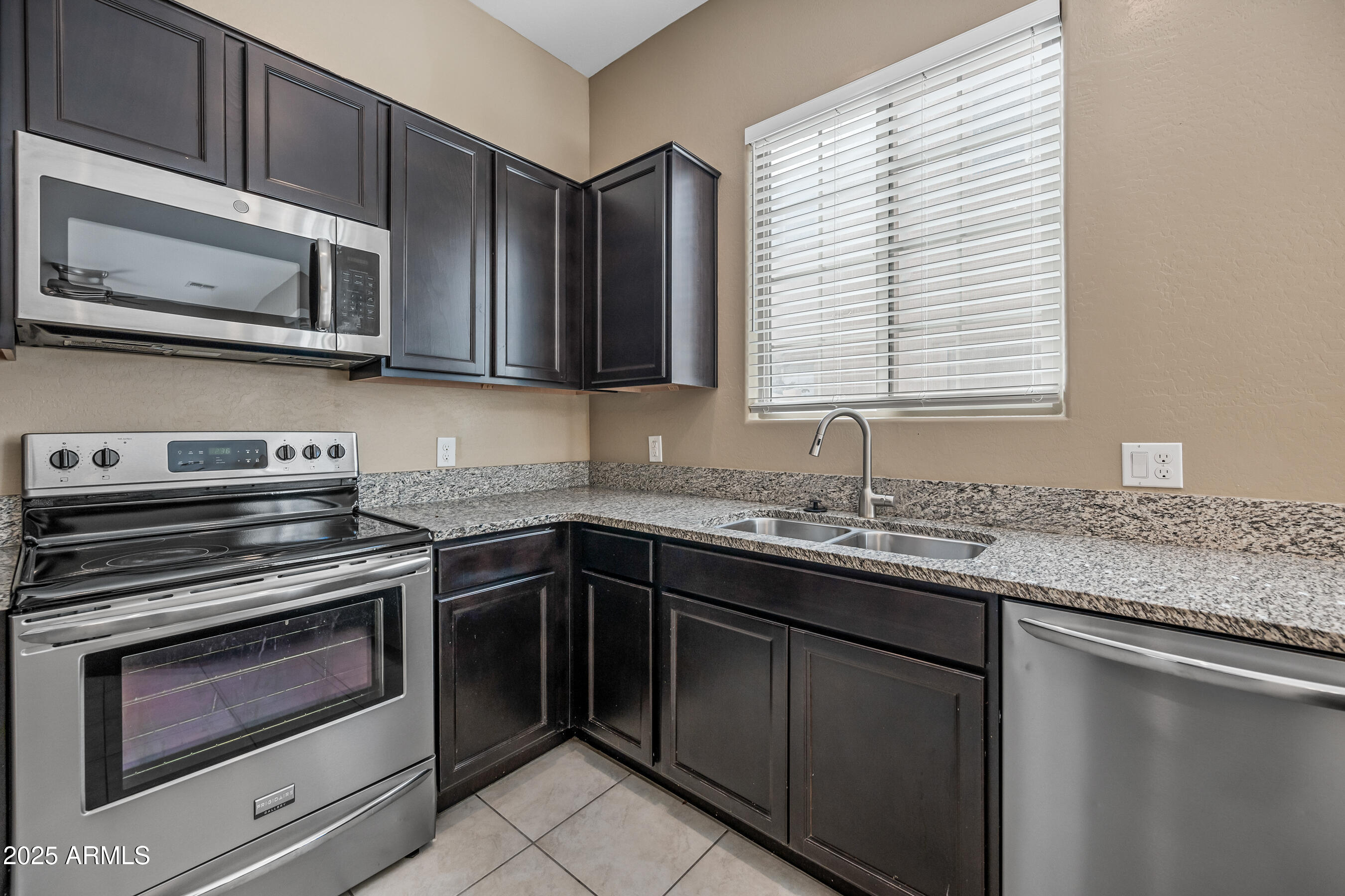 1367 South Country Club Drive, Unit 1131 Mesa, AZ 85210 - Photo 9 of 30 a kitchen with stainless steel appliances granite countertop white cabinets and a stove top oven