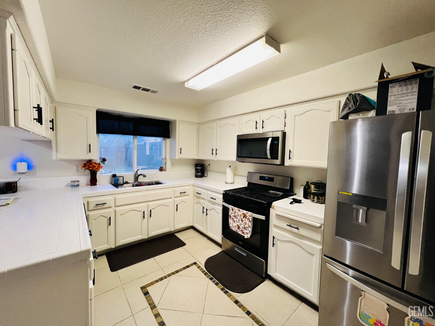 Undisclosed Address Wasco, CA 93280 - Photo 3 of 9 a kitchen with stainless steel appliances a refrigerator stove microwave and sink