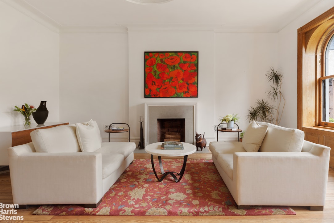 14 East 92nd Street, Unit 4 Manhattan, NY 10128 - Photo 2 of 8 a living room with furniture a rug and a fireplace