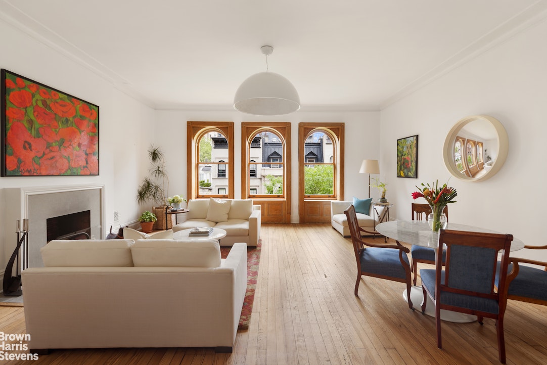 14 East 92nd Street, Unit 4 Manhattan, NY 10128 - Photo 7 of 8 a living room with furniture a fireplace and a large window
