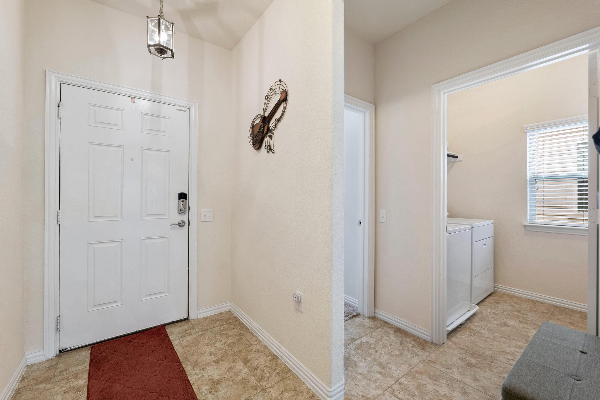 6905 Vail Ridge Street Austin, TX 78744 - Photo 4 of 39 Entryway opens to laundry area. Tile flooring in common areas downstairs.