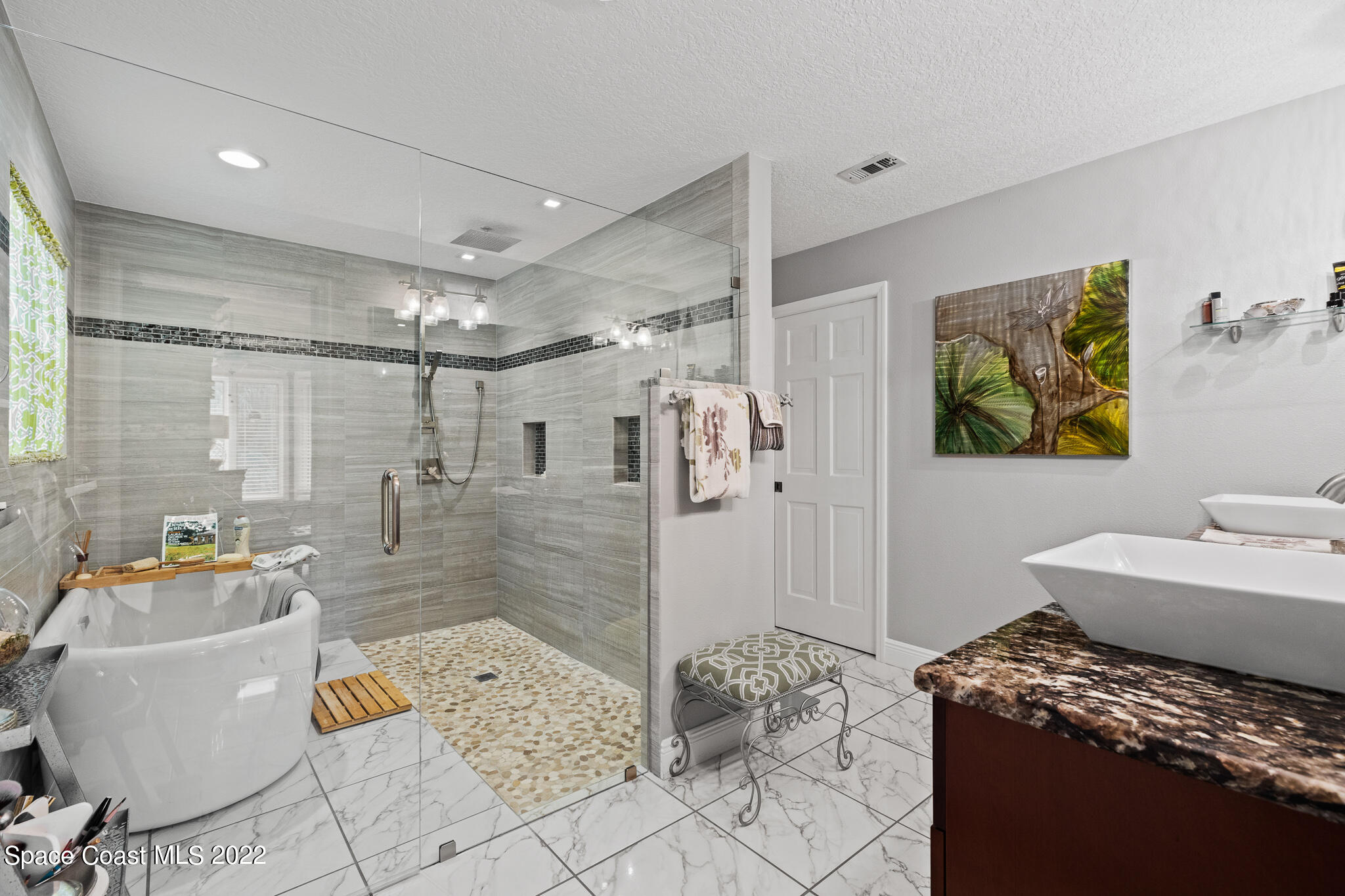 810 Kerry Downs Circle Melbourne, FL 32940 - Photo 32 of 59 a spacious bathroom with a granite countertop sink a mirror a bathtub and shower