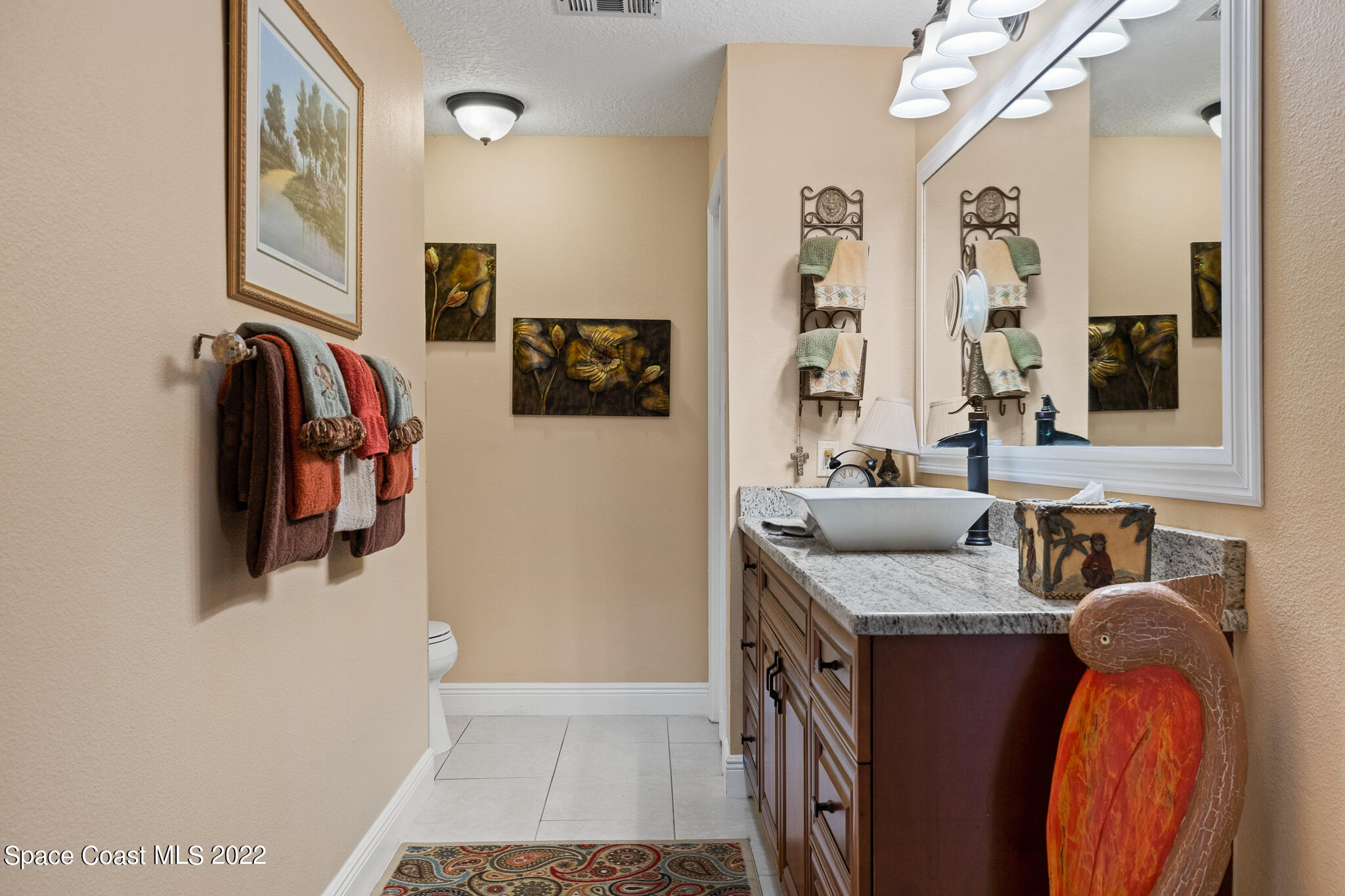 810 Kerry Downs Circle Melbourne, FL 32940 - Photo 38 of 59 a en suite bathroom with a granite countertop sink and a mirror