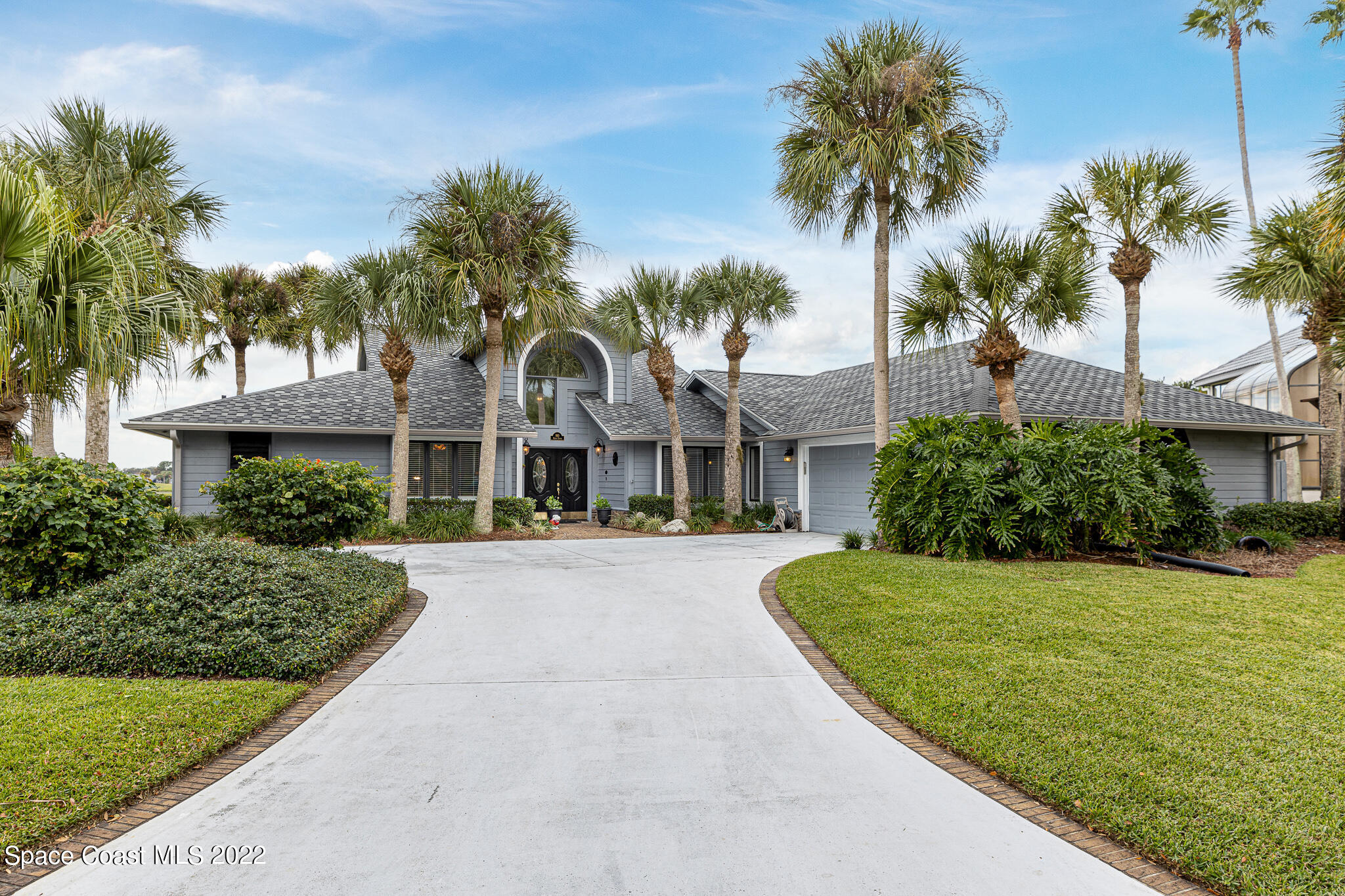810 Kerry Downs Circle Melbourne, FL 32940 - Photo 4 of 59 a front view of a house with a garden and palm trees