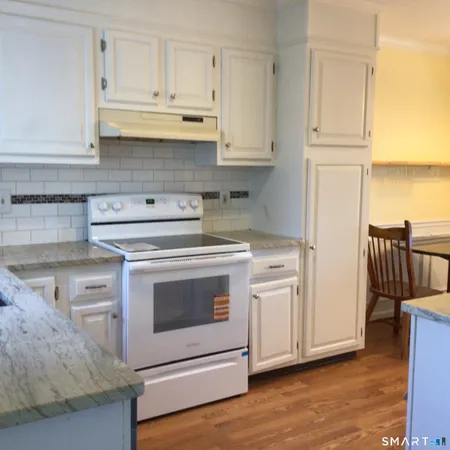 a kitchen with stainless steel appliances granite countertop a stove a microwave and a refrigerator