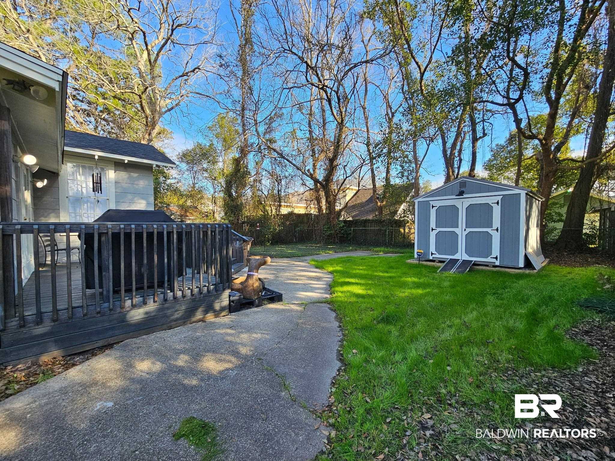 1215 Church Street Mobile, AL 36604 - Photo 20 of 23 View of yard featuring a shed, a deck, a fenced backyard, and an outbuilding