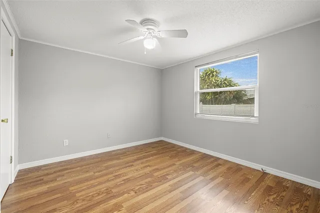 an empty room with a window and a ceiling fan