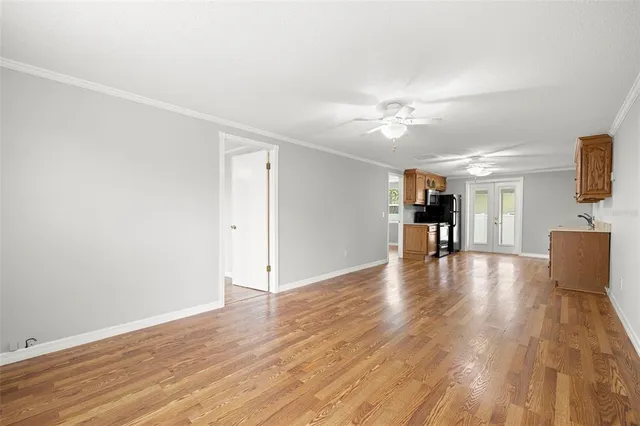 a view of empty room with wooden floor and a ceiling fan