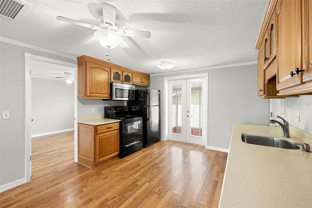 a kitchen with granite countertop a sink cabinets and stainless steel appliances