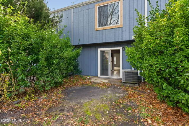 a view of a house with a small yard and a tree