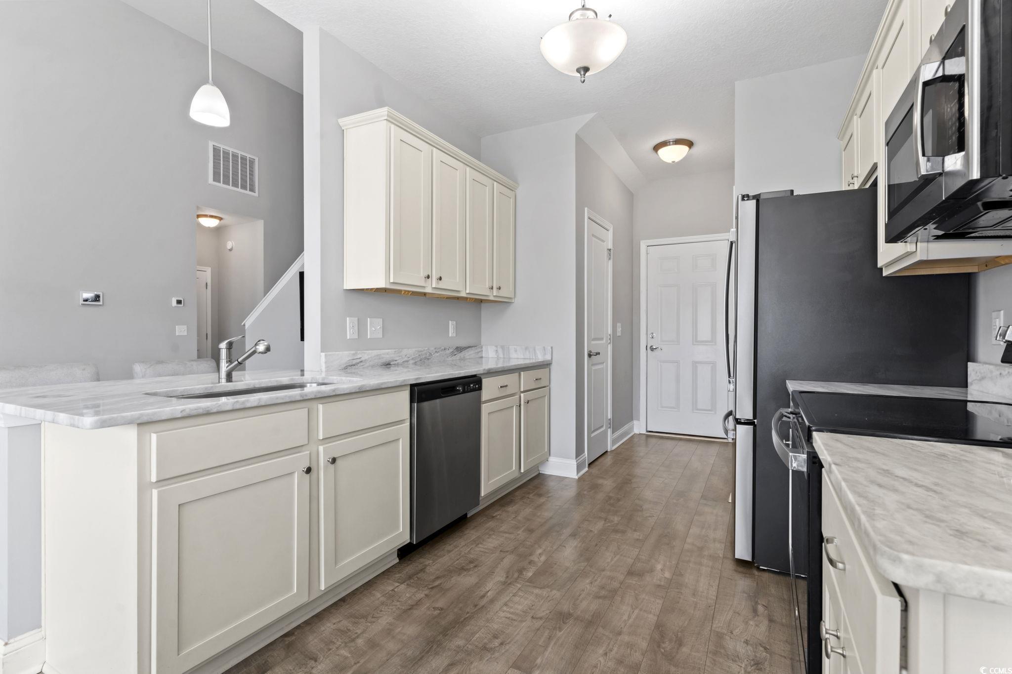 712 Hobonny Loop Longs, SC 29568 - Photo 11 of 39 Kitchen with visible vents, appliances with stainless steel finishes, wood finished floors, a sink, and a peninsula