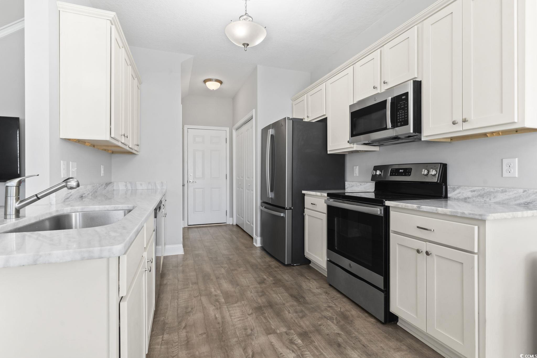 712 Hobonny Loop Longs, SC 29568 - Photo 12 of 39 Kitchen with white cabinetry, appliances with stainless steel finishes, dark wood-style floors, and a sink