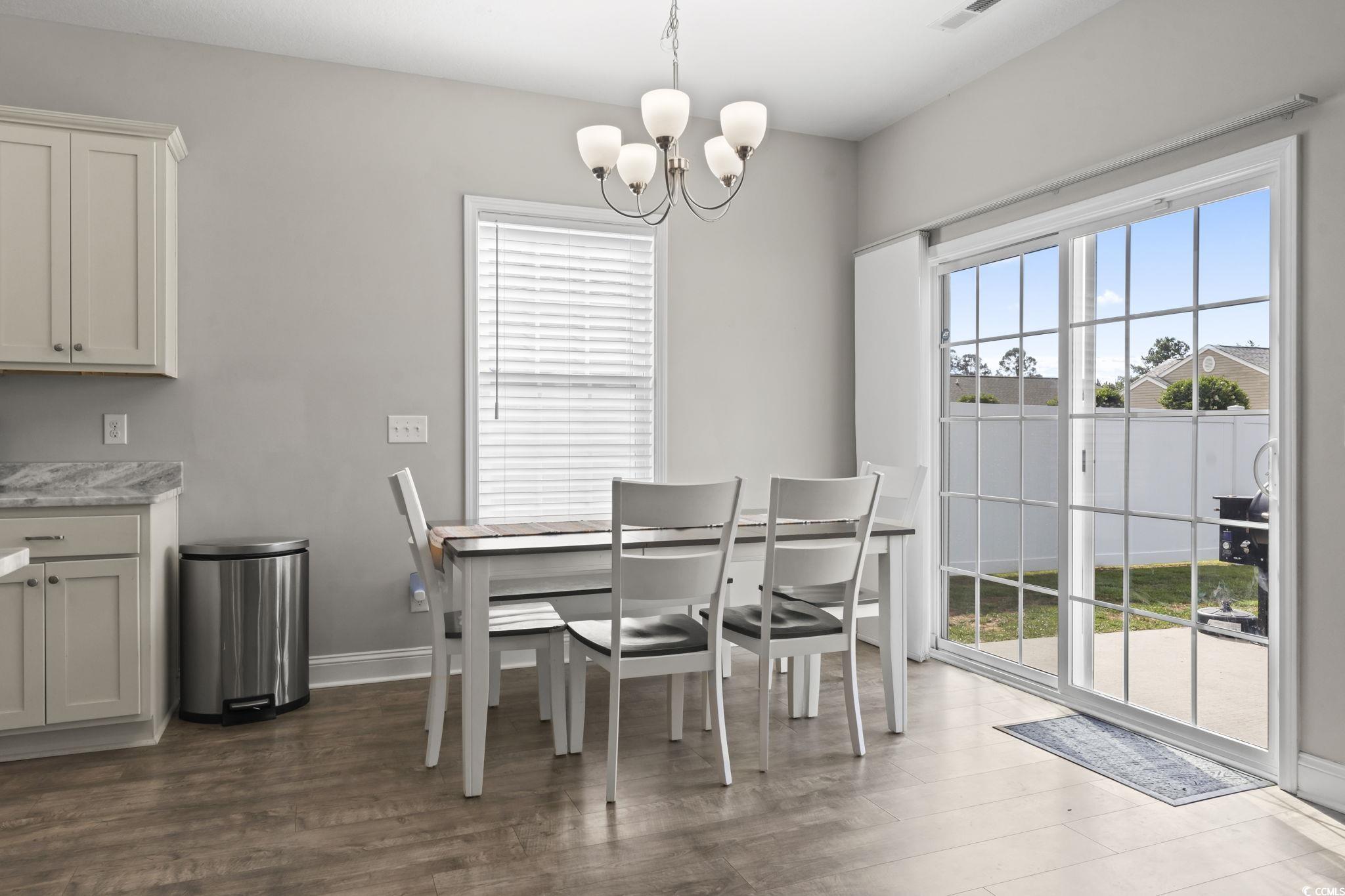712 Hobonny Loop Longs, SC 29568 - Photo 16 of 39 Dining space with dark wood-style flooring, baseboards, and an inviting chandelier