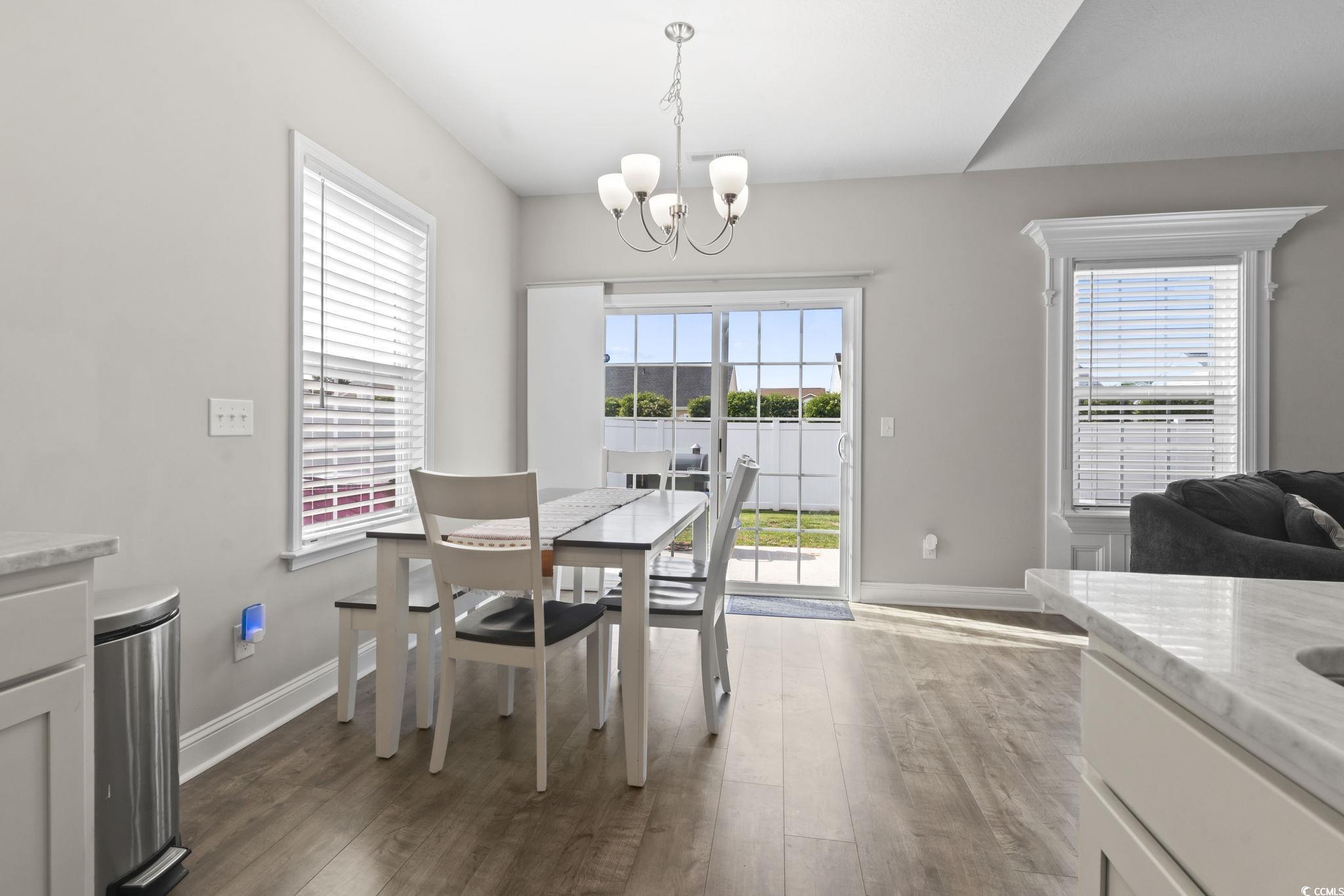 712 Hobonny Loop Longs, SC 29568 - Photo 17 of 39 Dining area featuring baseboards, wood finished floors, and a notable chandelier