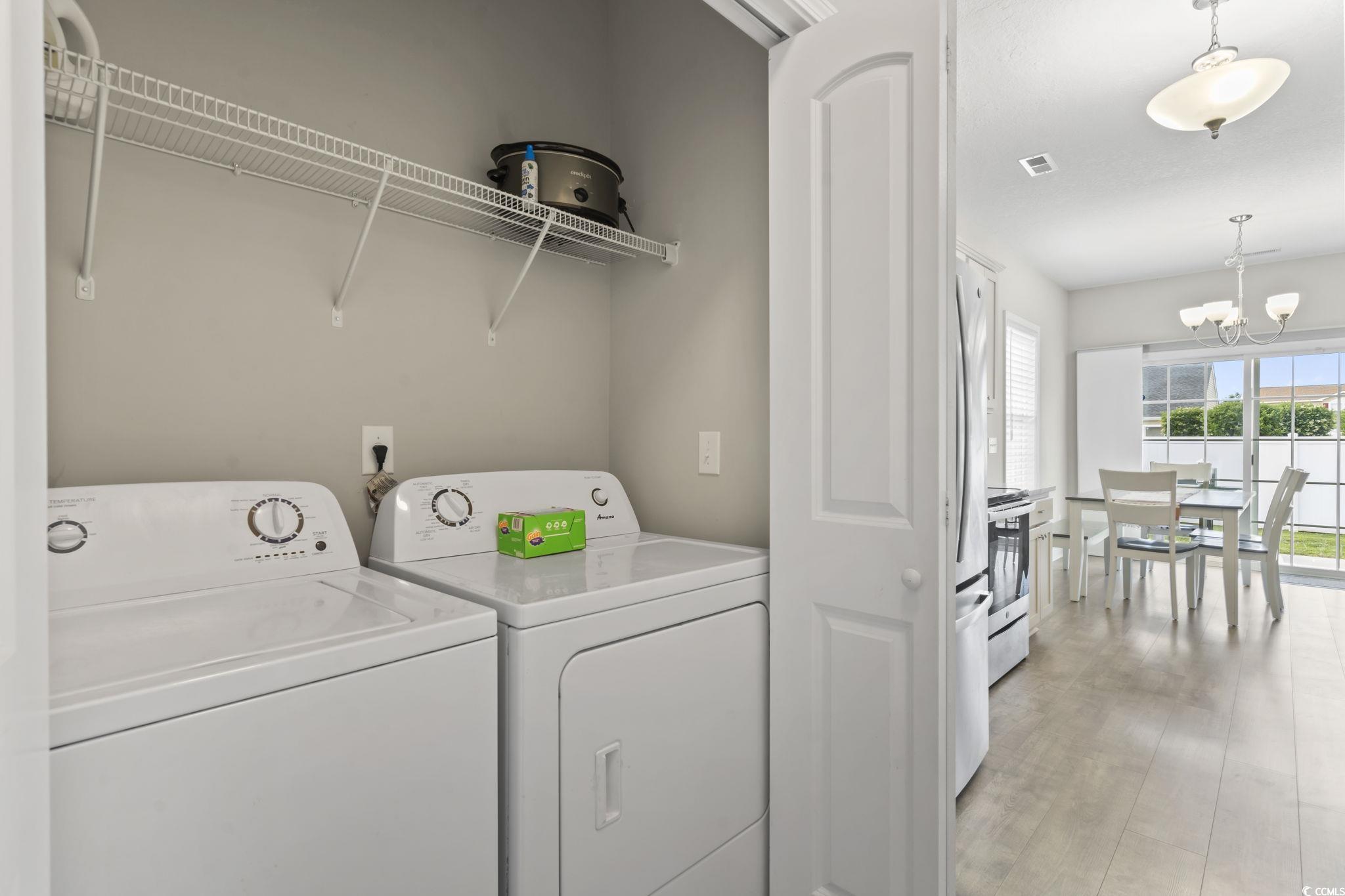 712 Hobonny Loop Longs, SC 29568 - Photo 27 of 39 Laundry area with laundry area, an inviting chandelier, light wood finished floors, visible vents, and washing machine and dryer