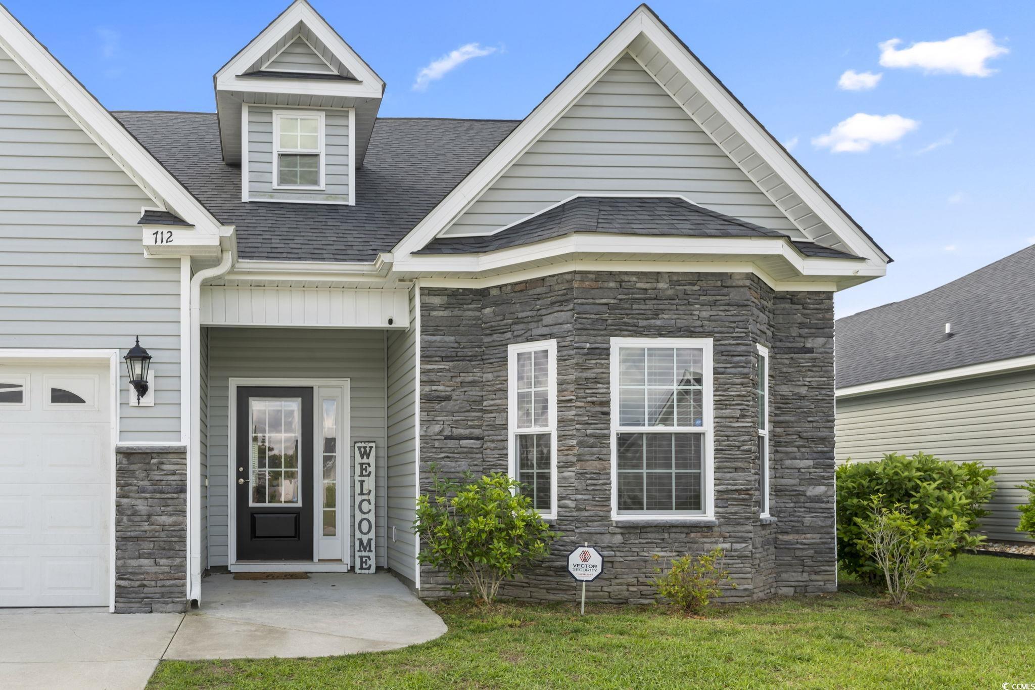 712 Hobonny Loop Longs, SC 29568 - Photo 36 of 39 Property entrance featuring a lawn, a shingled roof, and stone siding