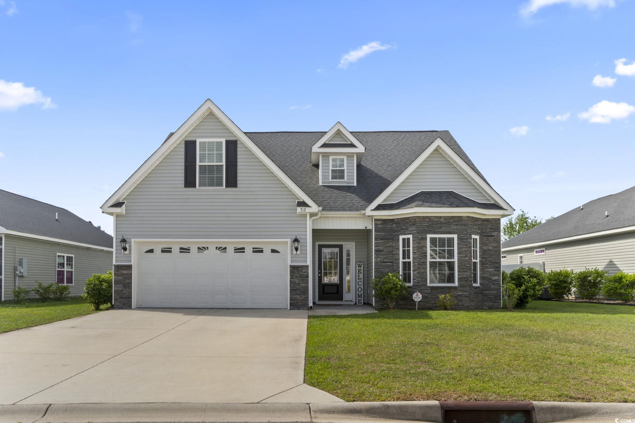 712 Hobonny Loop Longs, SC 29568 - Photo 38 of 39 View of front facade featuring driveway, roof with shingles, a front yard, a garage, and stone siding