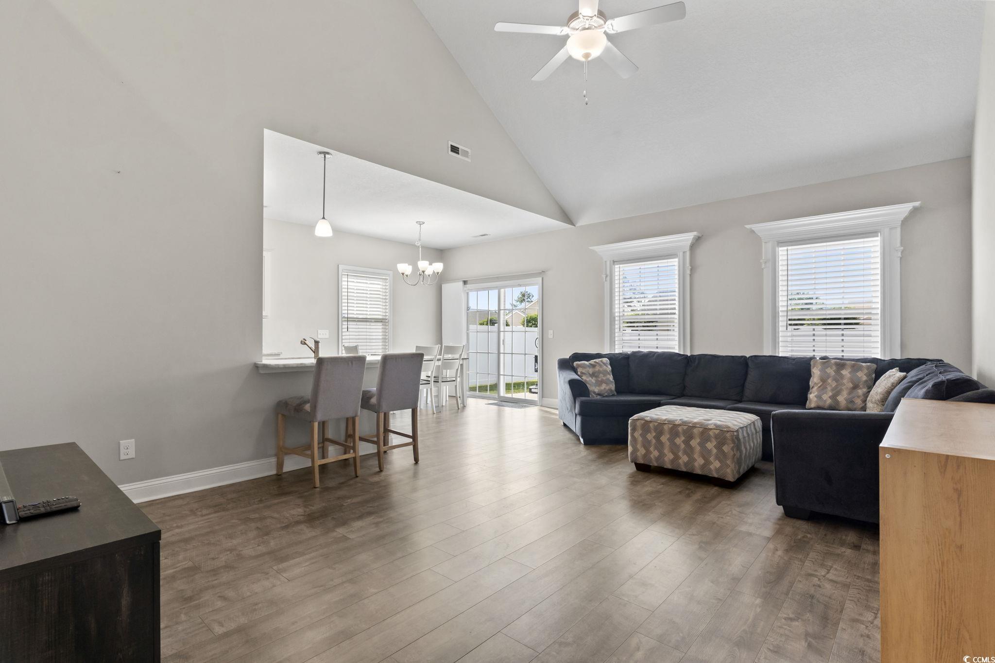 712 Hobonny Loop Longs, SC 29568 - Photo 8 of 39 Living room featuring ceiling fan with notable chandelier, lofted ceiling, wood finished floors, and visible vents