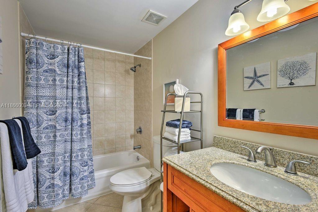 2280 Southwest 32nd Avenue, Unit 509 Miami, FL 33145 - Photo 18 of 22 a bathroom with a granite countertop sink toilet and shower