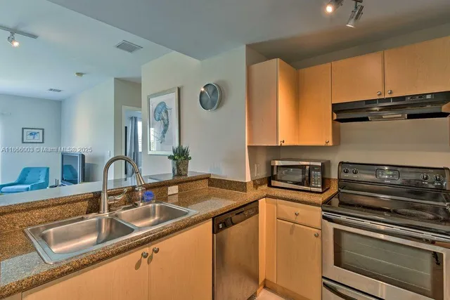 a kitchen with stainless steel appliances granite countertop a sink stove and microwave