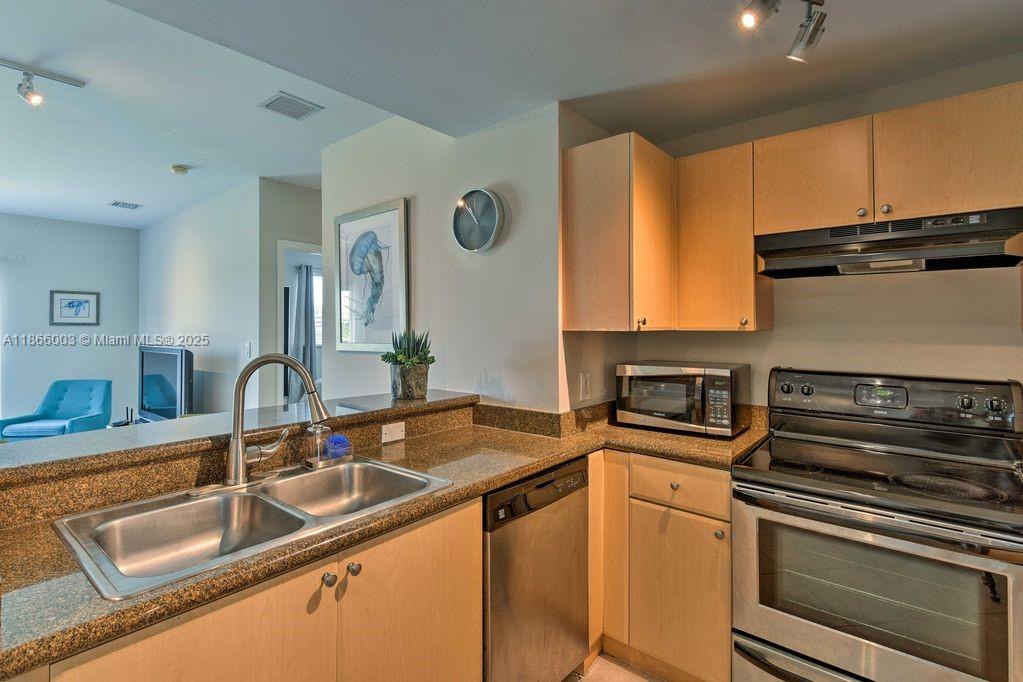 2280 Southwest 32nd Avenue, Unit 509 Miami, FL 33145 - Photo 3 of 26 a kitchen with stainless steel appliances granite countertop a sink stove and microwave