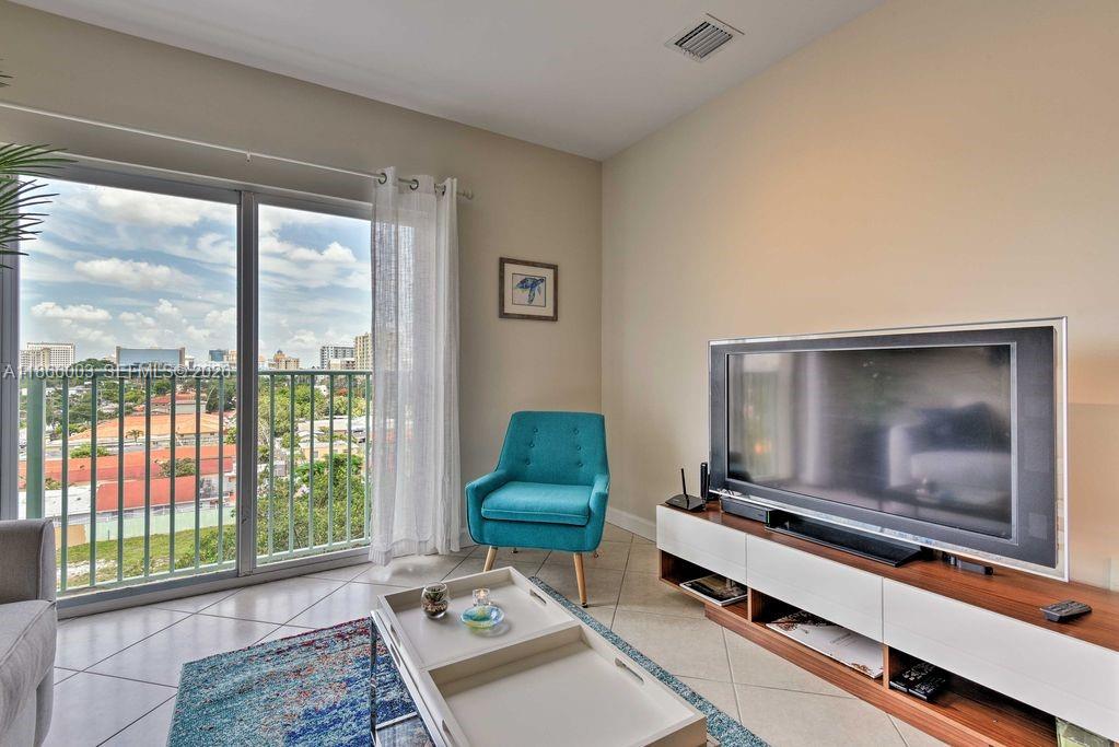 2280 Southwest 32nd Avenue, Unit 509 Miami, FL 33145 - Photo 3 of 22 a living room with a flat screen tv and a floor to ceiling window