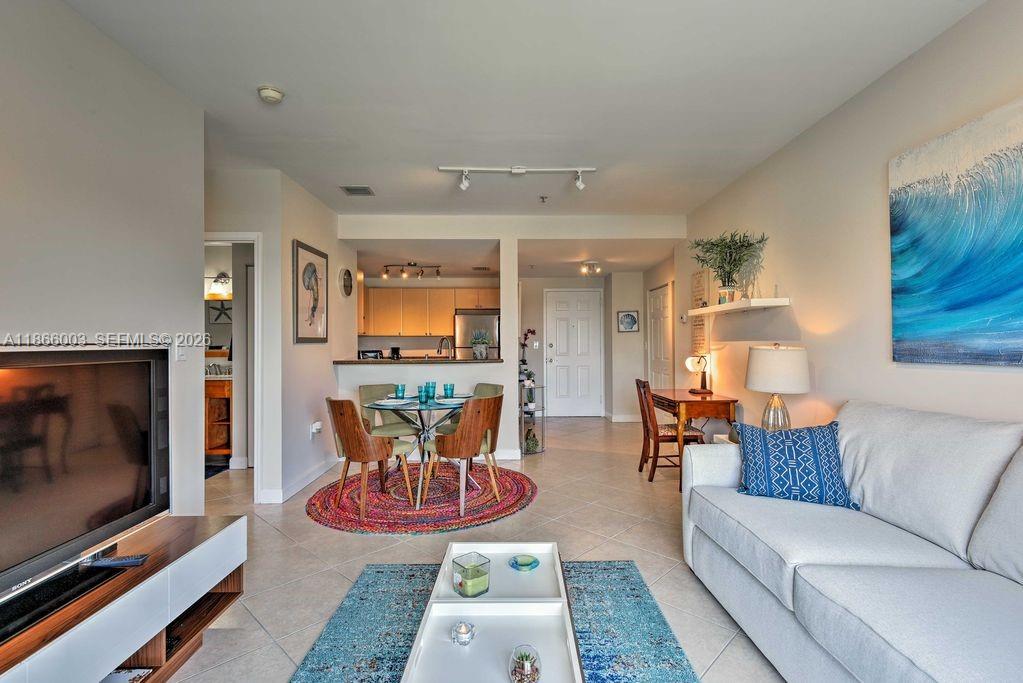 2280 Southwest 32nd Avenue, Unit 509 Miami, FL 33145 - Photo 8 of 22 a living room with furniture a flat screen tv and a floor to ceiling window