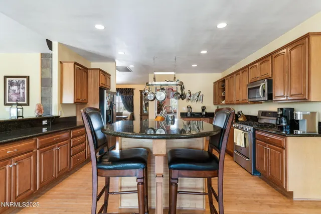 a kitchen with stainless steel appliances granite countertop a sink a oven and a refrigerator