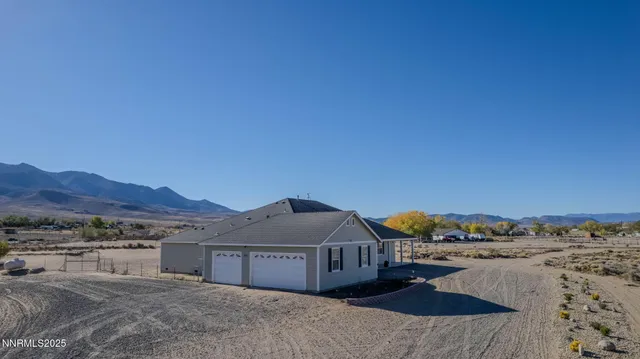 a view of a dry yard with mountains in the background