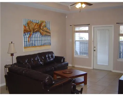 a black leather couch in a living room next to a window