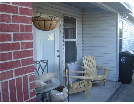 a view of a chair and fire pit in front of brick house