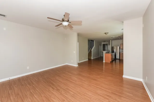 a view of a room with wooden floor and a ceiling fan