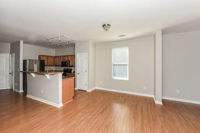 a view of kitchen with stainless steel appliances kitchen island hard wood floors and stove