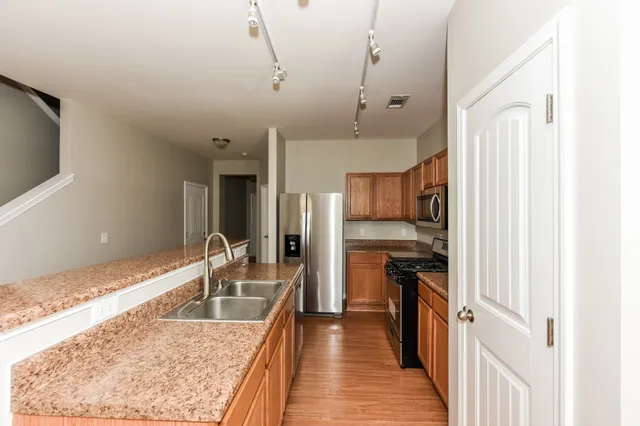a kitchen with granite countertop a sink stove and refrigerator