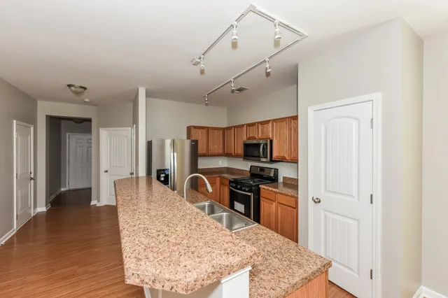a kitchen with stainless steel appliances granite countertop a sink stove and refrigerator