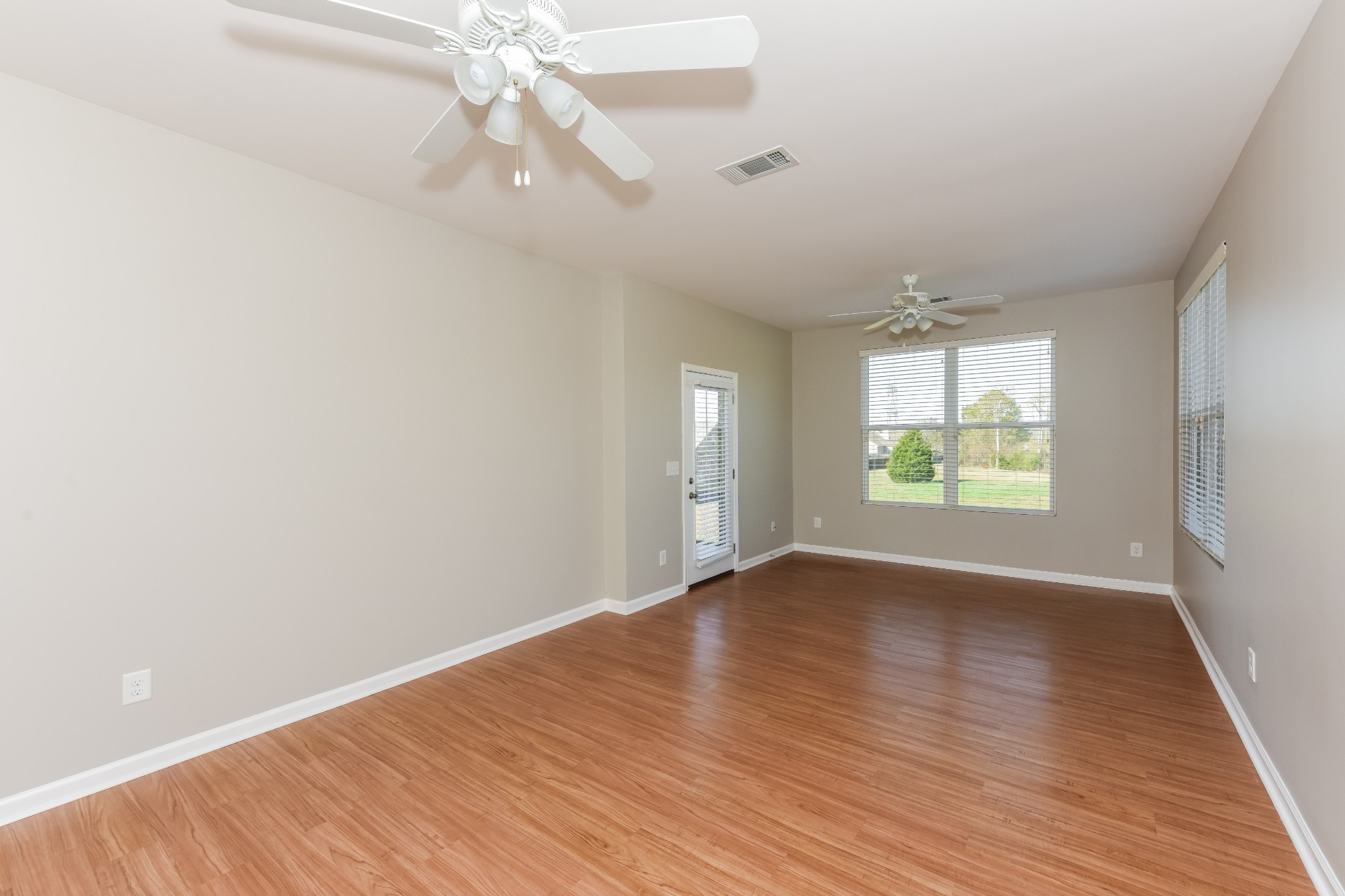 2015 Lincoln Road Spring Hill, TN 37174 - Photo 8 of 17 an empty room with wooden floor chandelier fan and windows