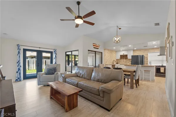 a living room with furniture and a view of kitchen