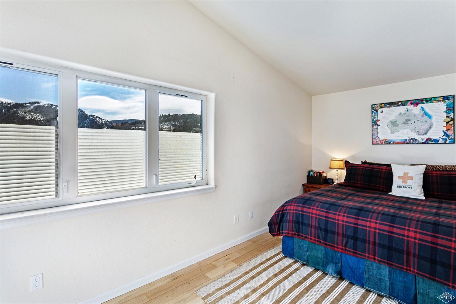 13 Eagle Drive, Unit B Avon, CO 81620 - Photo 12 of 25 a bedroom with a bed and wooden floor