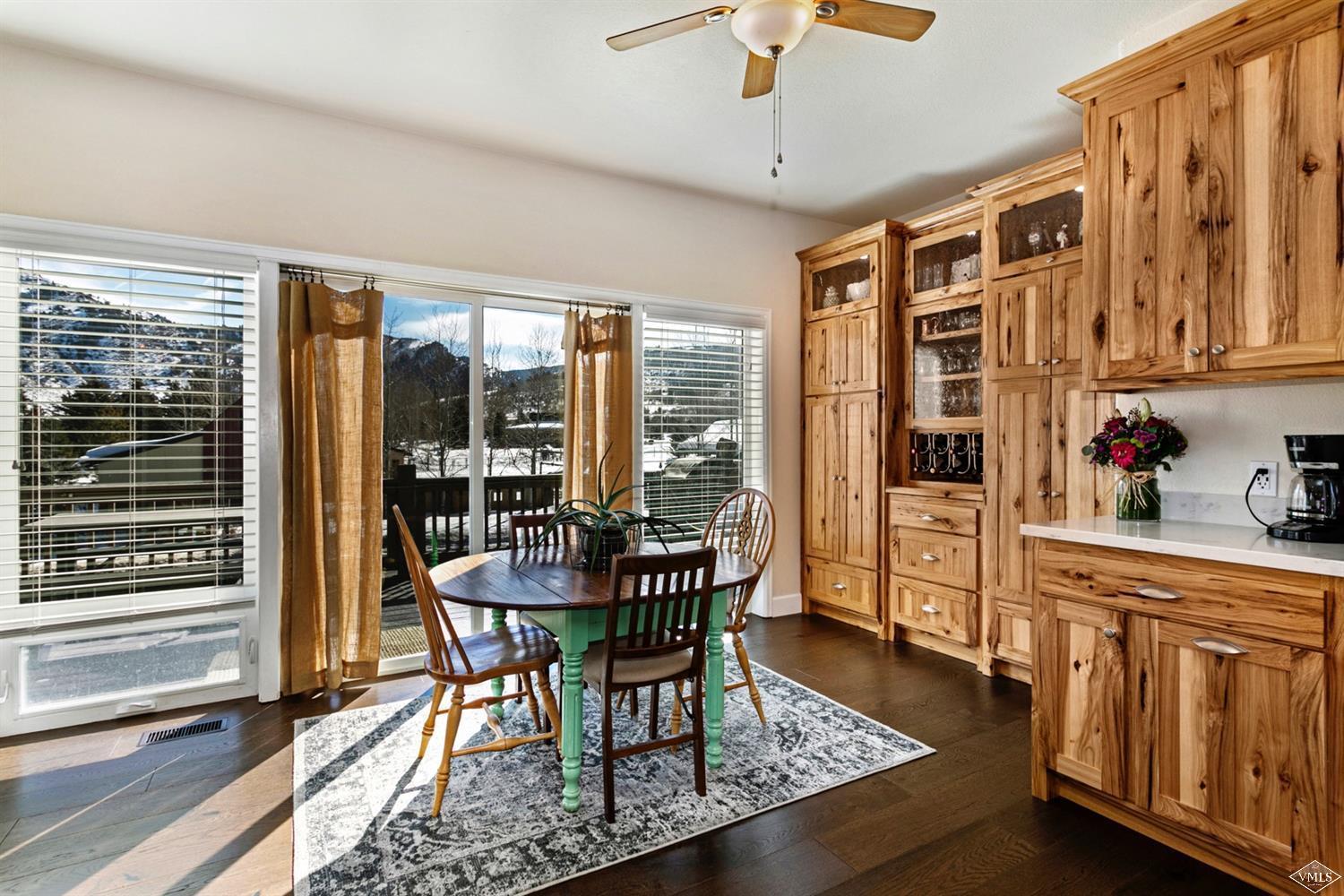 13 Eagle Drive, Unit B Avon, CO 81620 - Photo 2 of 25 a dining room with wooden floor a chandelier a glass table and chairs