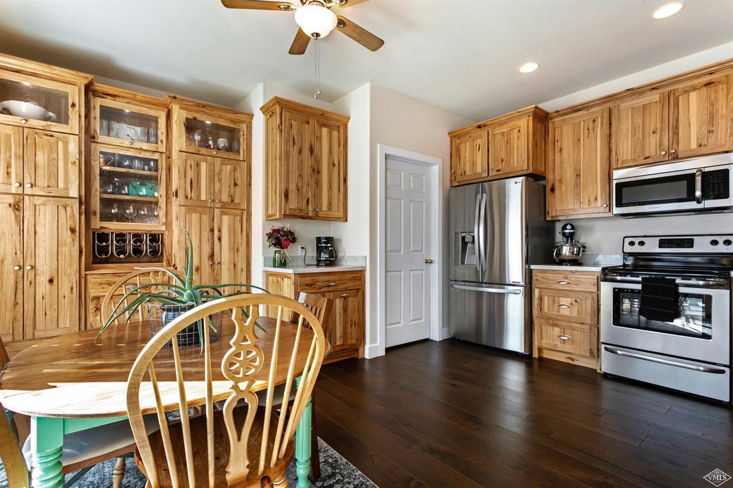 13 Eagle Drive, Unit B Avon, CO 81620 - Photo 3 of 25 a kitchen with stainless steel appliances wooden floors a stove and a refrigerator