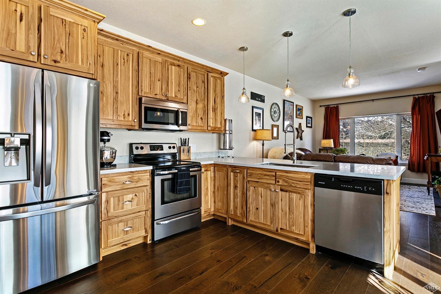 13 Eagle Drive, Unit B Avon, CO 81620 - Photo 4 of 25 a kitchen with stainless steel appliances granite countertop a refrigerator a stove top oven a sink and dishwasher with wooden floor