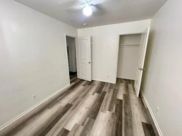 a view of a bedroom with wooden floor and staircase