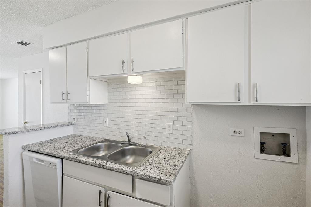 2637 West Randol Mill Road, Unit 2639D Arlington, TX 76012 - Photo 1 of 15 Kitchen featuring white cabinetry, a double basin stainless steel sink, a subway tile backsplash, and speckled countertops