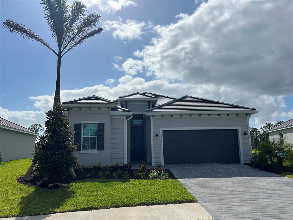 17535 Jadestone Court Venice, FL 34293 - Photo 2 of 92 a front view of a house with a garden and trees