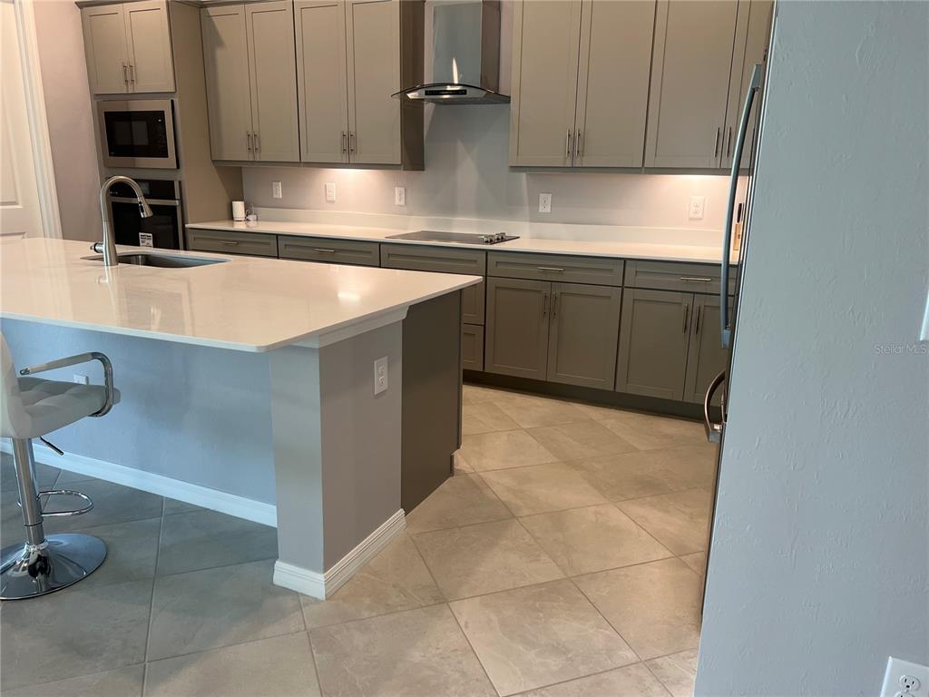 17535 Jadestone Court Venice, FL 34293 - Photo 10 of 92 a kitchen with stainless steel appliances granite countertop a sink stove and refrigerator