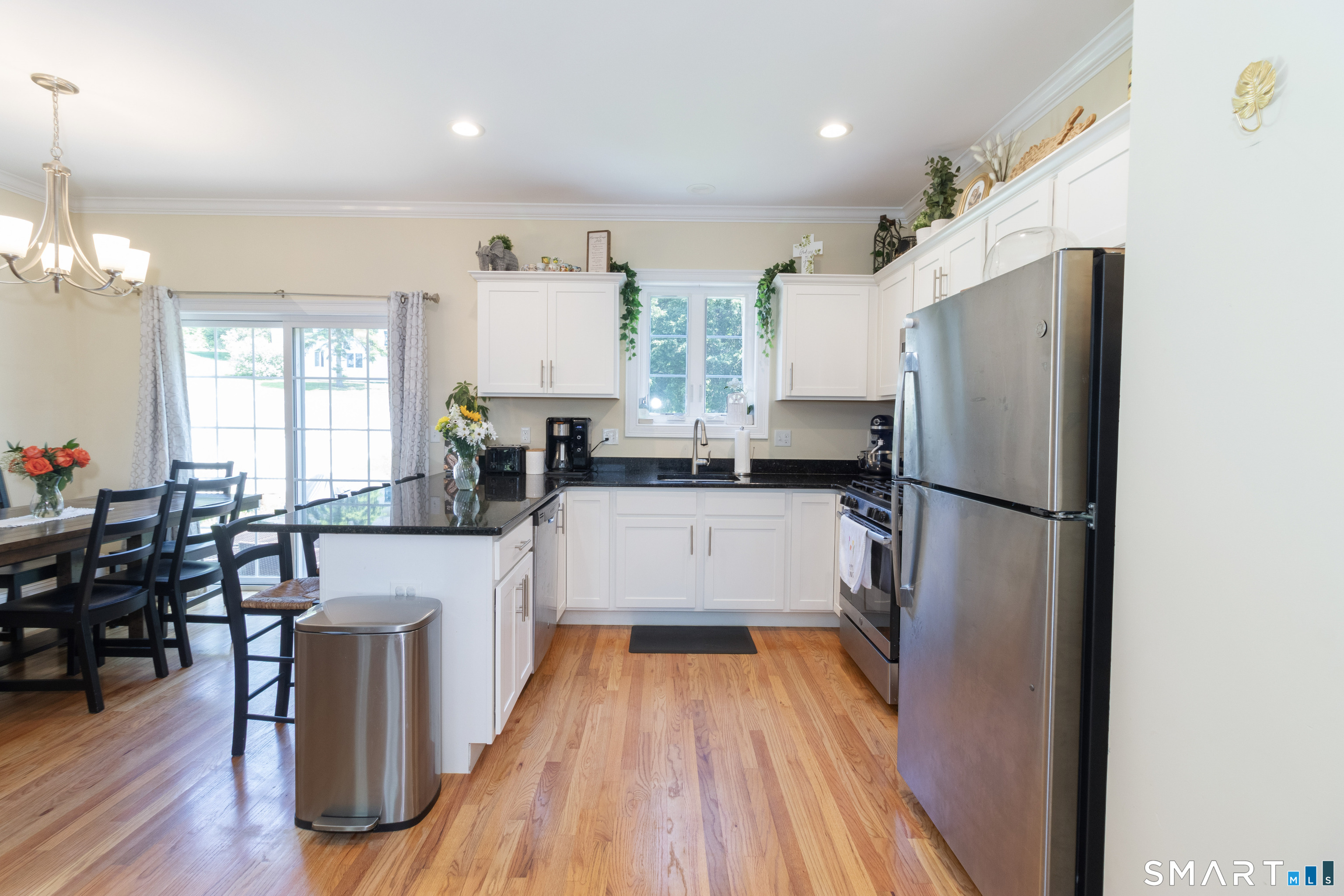 656 Bartholomew Road, Unit 656 Middletown, CT 06457 - Photo 9 of 27 a kitchen with stainless steel appliances a refrigerator a sink dishwasher a stove and white countertops with wooden floor