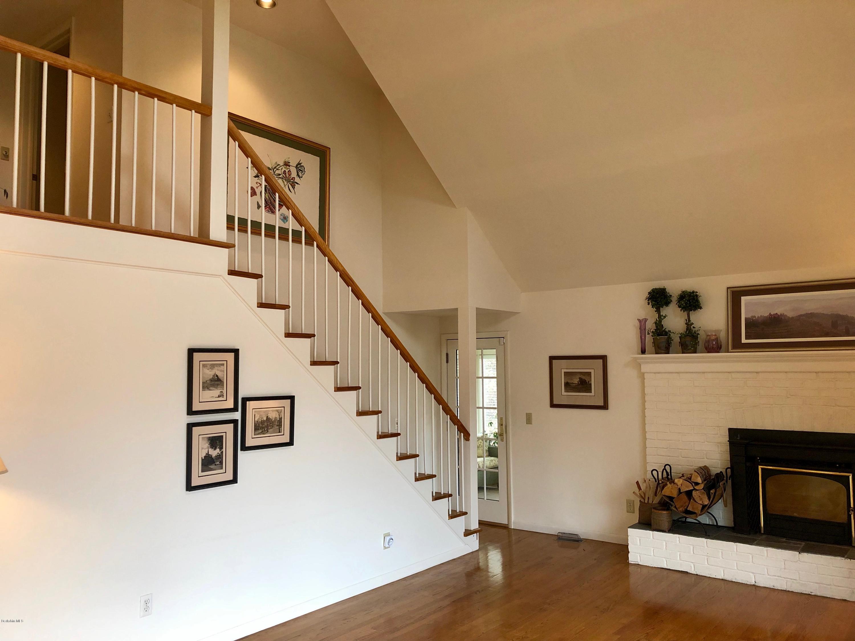 90 Lenox Road West Stockbridge, MA 01266 - Photo 9 of 23 a view of staircase with fireplace and lots of frames on wall