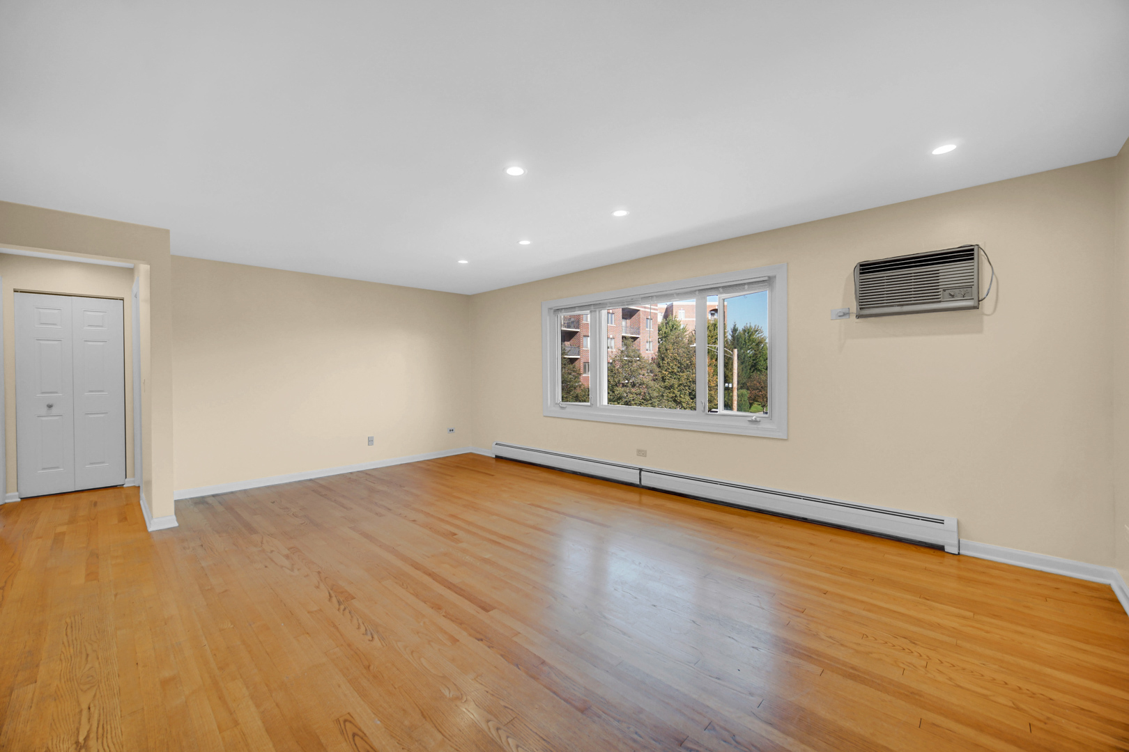 1211 Brown Street, Unit 3B Des Plaines, IL 60016 - Photo 3 of 14 a view of an empty room with wooden floor and a window