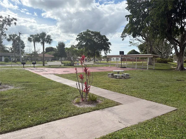 a park view with a fountain plants and trees